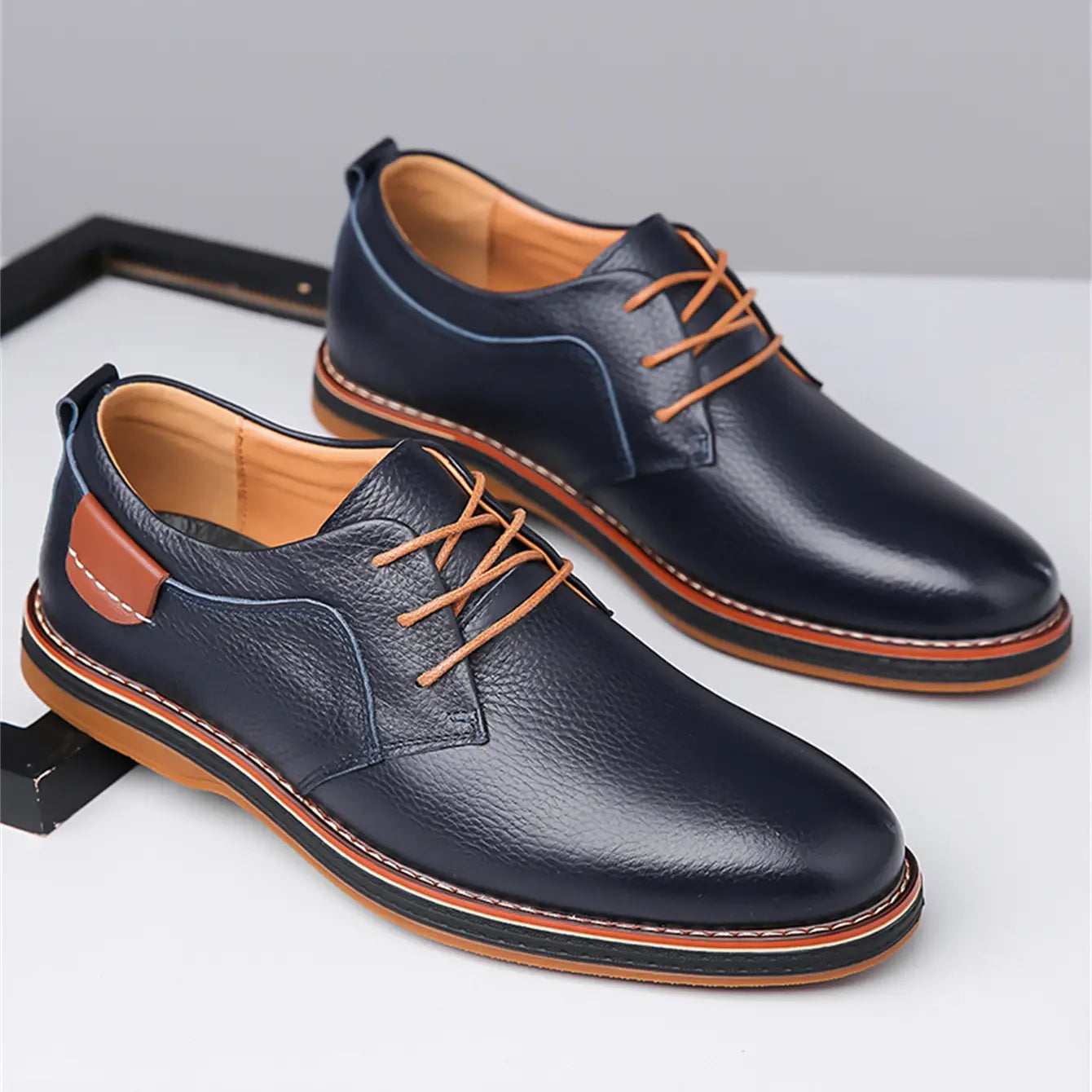 Men’s handmade genuine leather lace up Oxford shoes in dark blue leather with tan laces and contrasting brown stitching along the sole