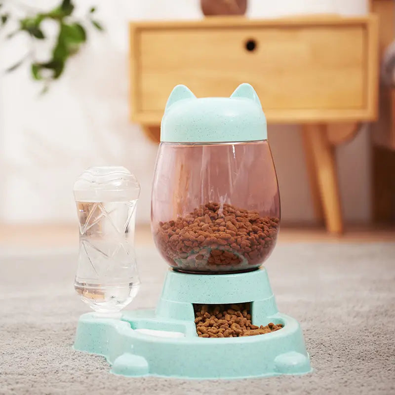 Light blue cat-shaped automatic cat feeder with transparent body and food dispensing base for convenient pet feeding.