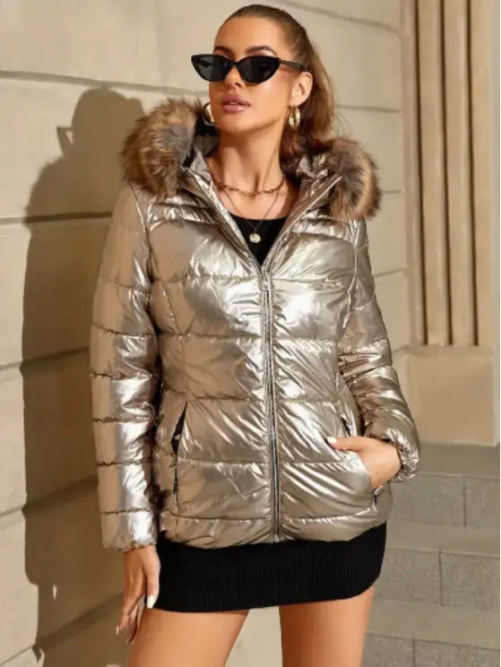 Shiny metallic silver women’s hooded puffer jacket with fur-lined hood made of insulated material for cold weather.
