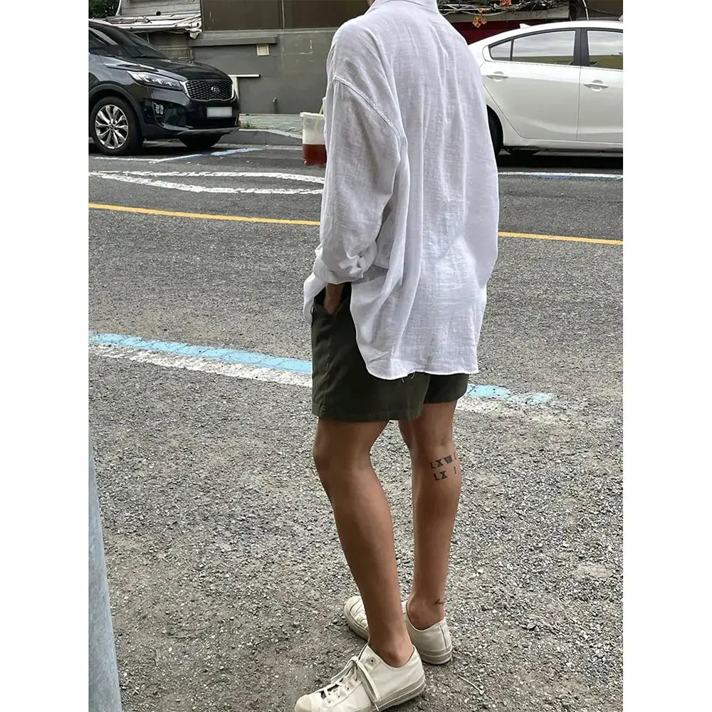 White loose-fitting linen button up shirt with rolled-up sleeves in Korean style.