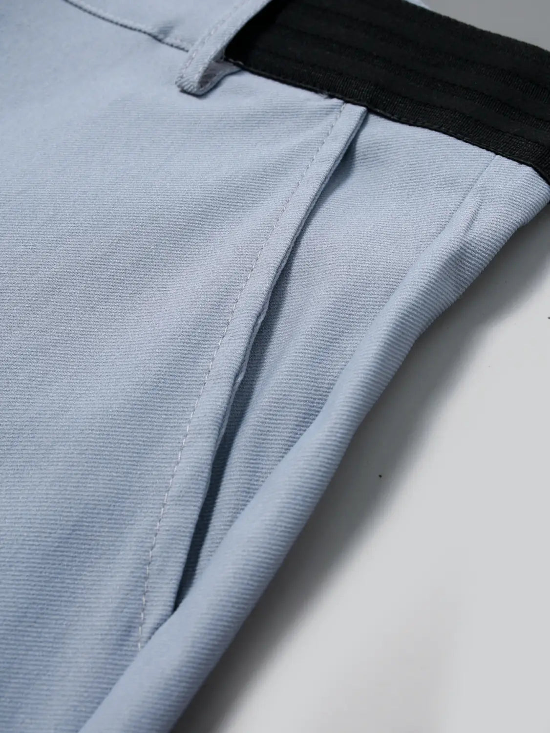 Men’s slim fit high stretch light gray business trousers featuring light blue woven fabric pants with a black elastic waistband.