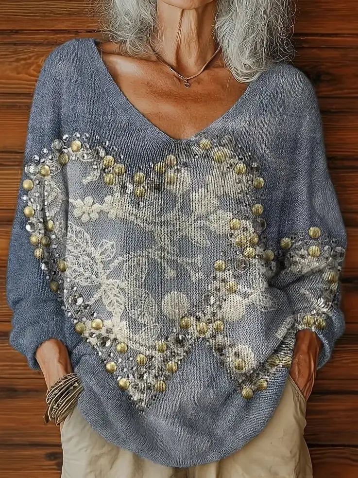 Un suéter de punto esponjoso azul suave que presenta un delicado patrón floral blanco y abalorios con tono dorado dispuestos en un diseño con forma de corazón en la parte delantera, denominado suéter esponjoso de gato navideño bordado.