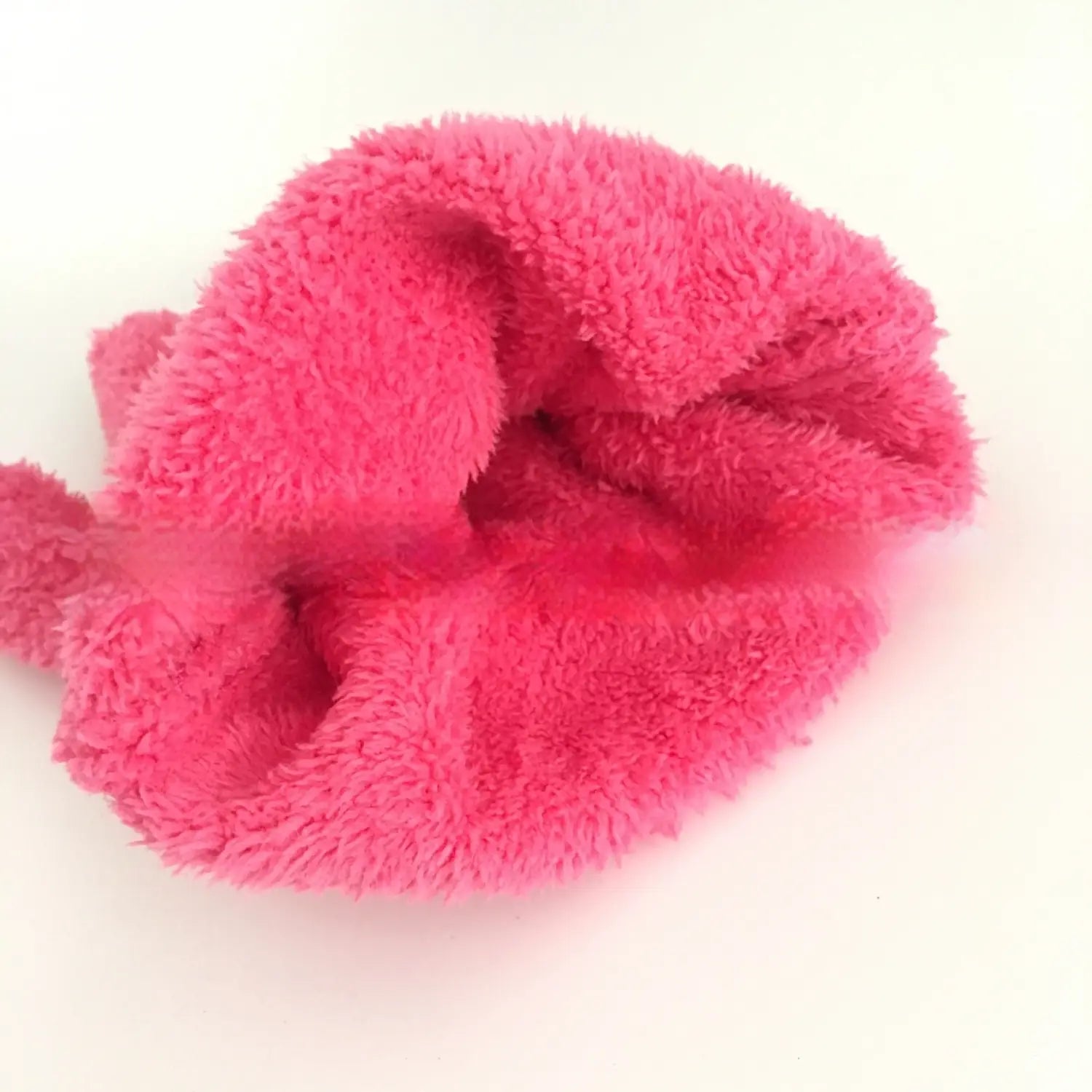 A plush coral fleece bath dust glove with a bright pink microfiber scrunchie featuring a soft fuzzy texture.