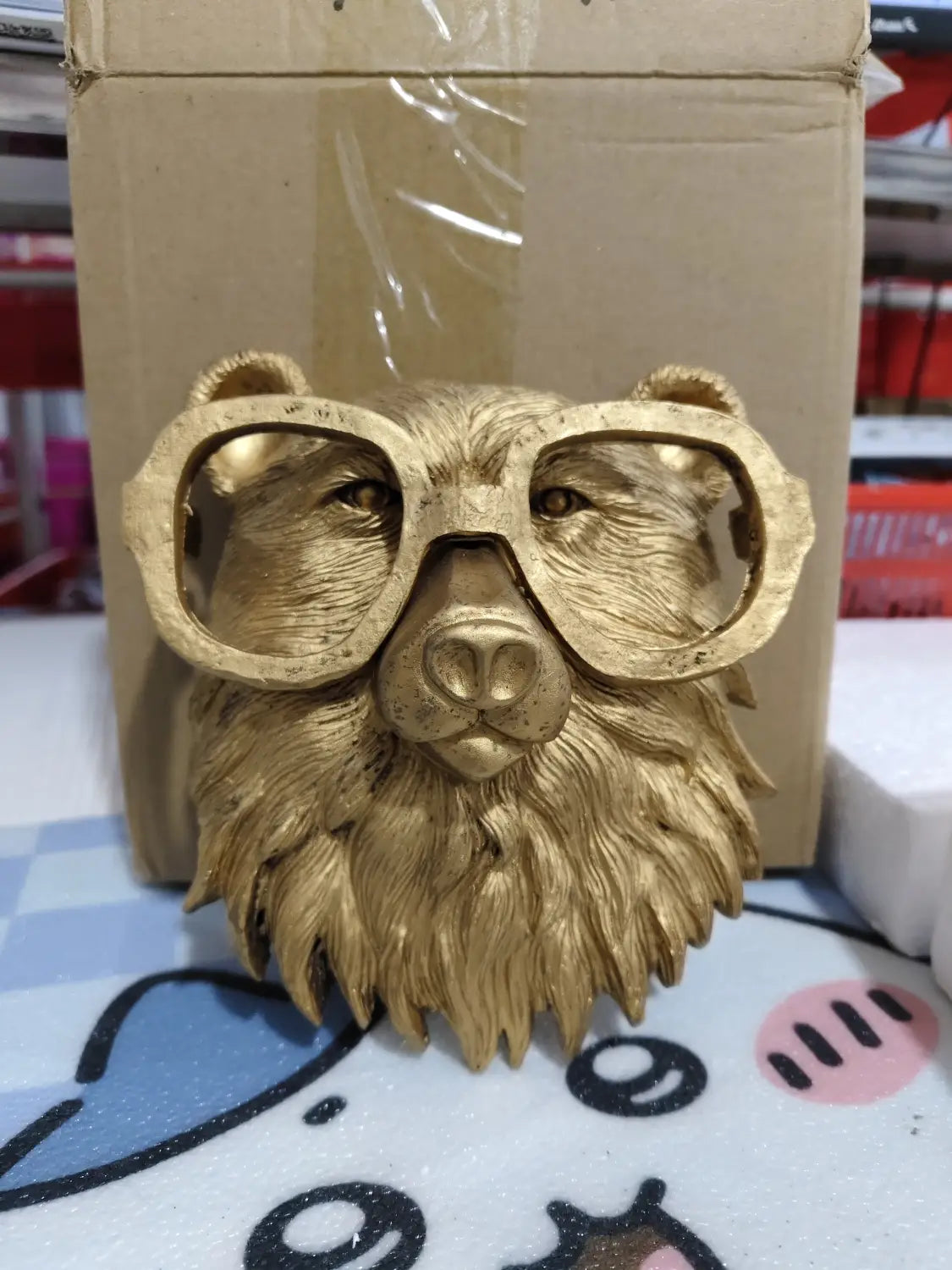 Golden bear head wall decor sculpture in brass resin wearing oversized glasses as an animal head wall figurine.