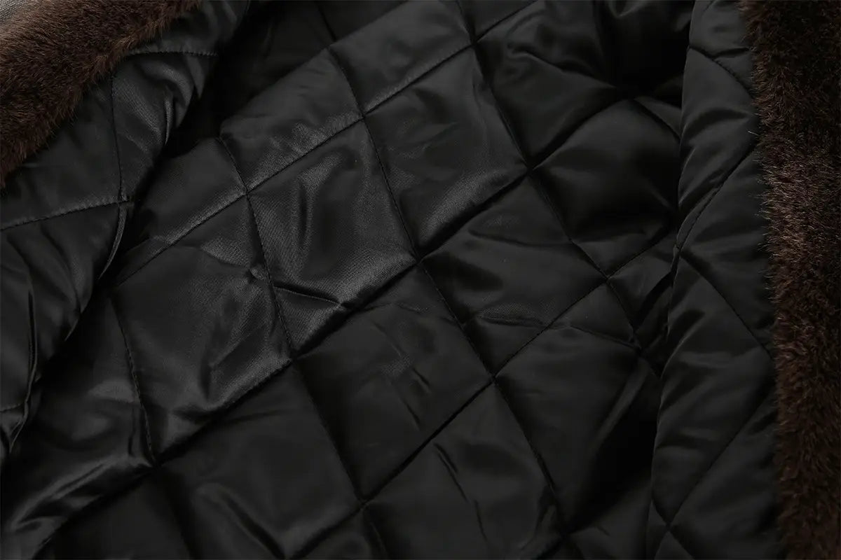 Chaqueta acolchada tipo puffer en color negro con capucha forrada con piel marrón, confeccionada con material acolchado de algodón, diseñada para uso de invierno para hombre y mujer.