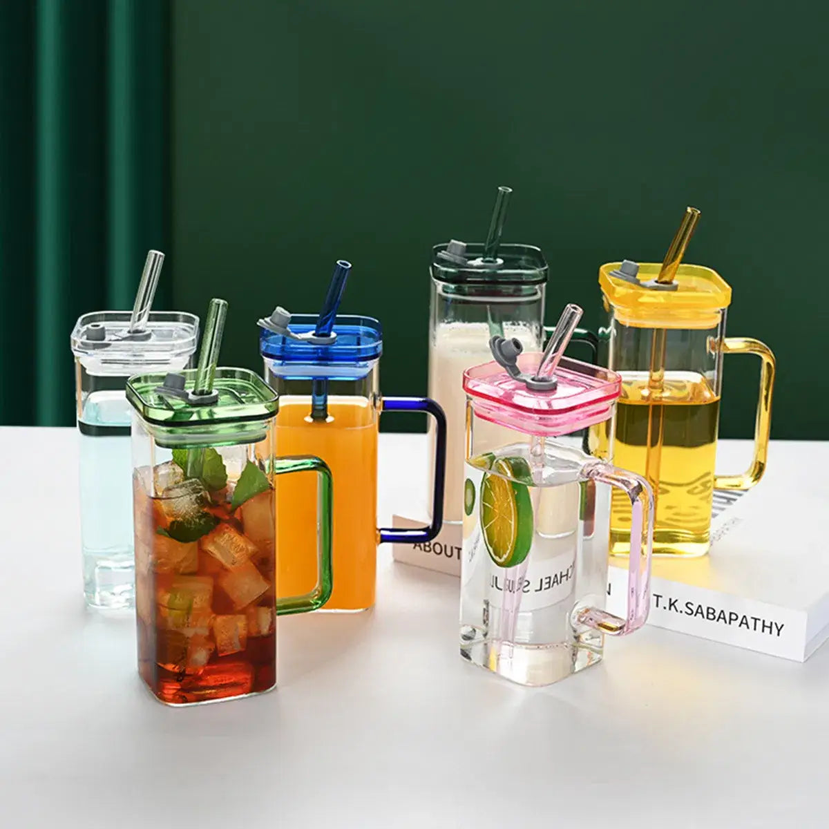 Tasses carrées en verre transparent de 12 oz, avec des couvercles et des poignées colorés, chacune contenant une boisson différente