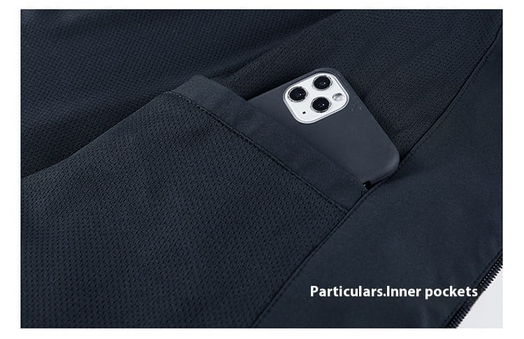 a black smartphone with a silver camera module rests in the inner pocket of a dark navy textured fabric men casual jacket lightweight outdoor windbreaker