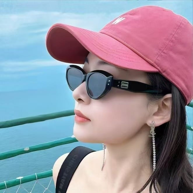 a pink baseball cap with a small white logo on the front paired with retro cat eye uv400 sunglasses featuring glossy modern frames