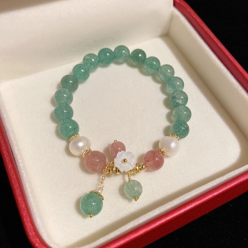 A delicate Korean floral green strawberry crystal beaded bracelet with jade and pink gemstones adorned with a white floral pendant and gold-toned accents.