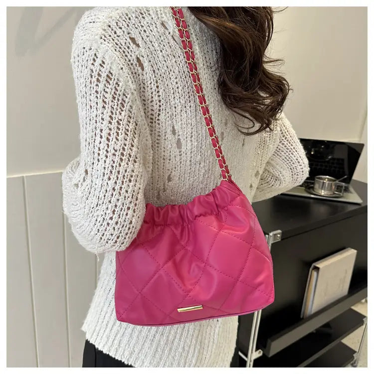 Vibrant pink quilted faux leather shoulder bag with chain strap designed as a crossbody accessory.