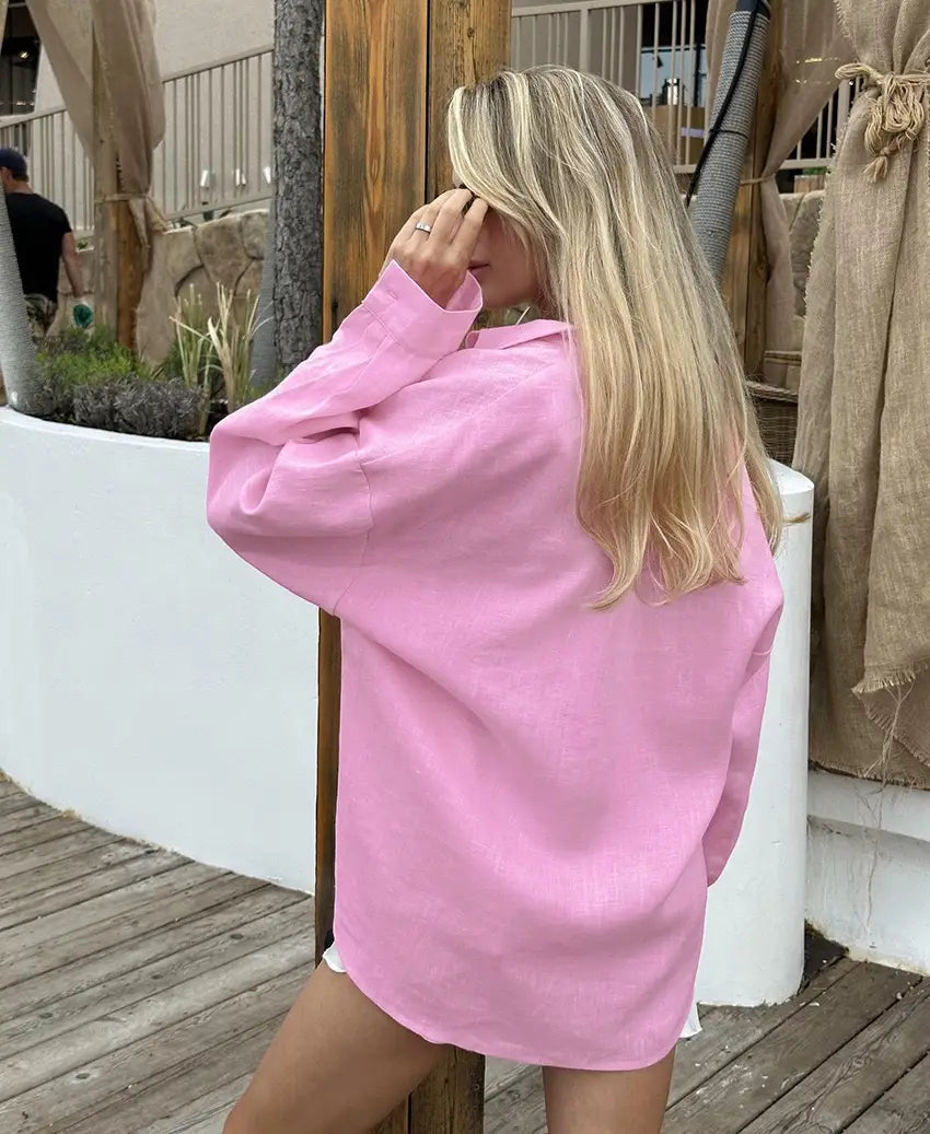 A soft pink oversized linen button up cardigan blouse with a relaxed fit and long sleeves for women.