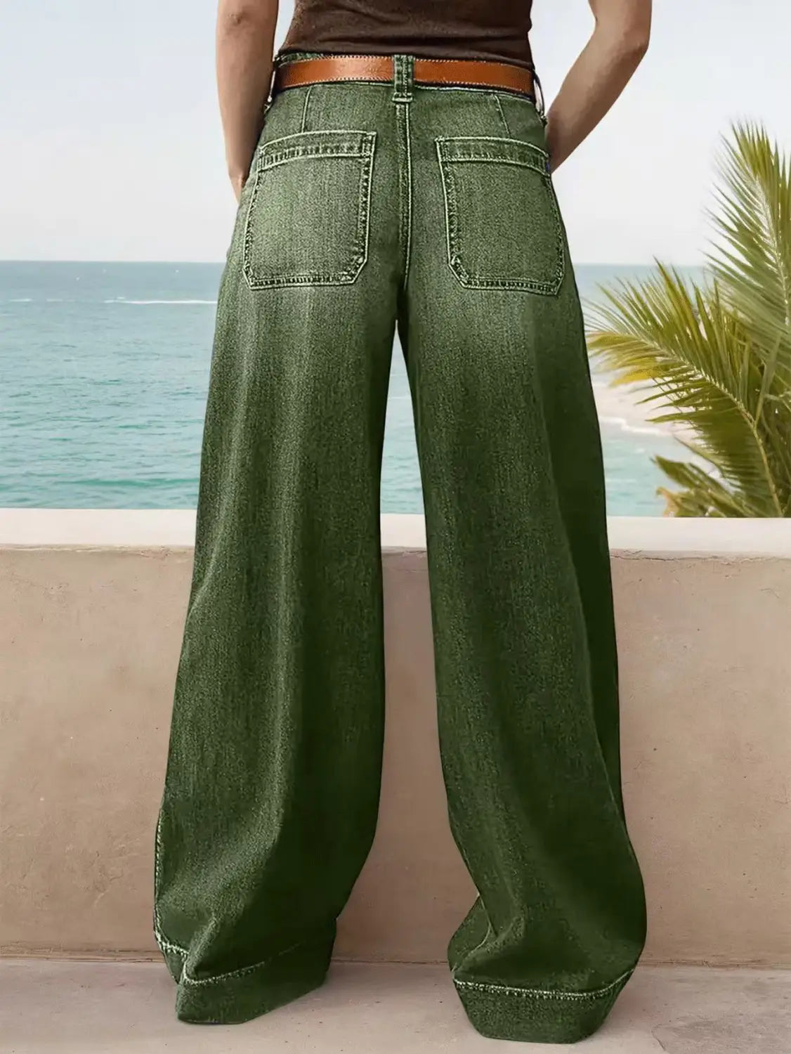 Green wide-leg denim pants with a brown leather belt showcasing the front side.