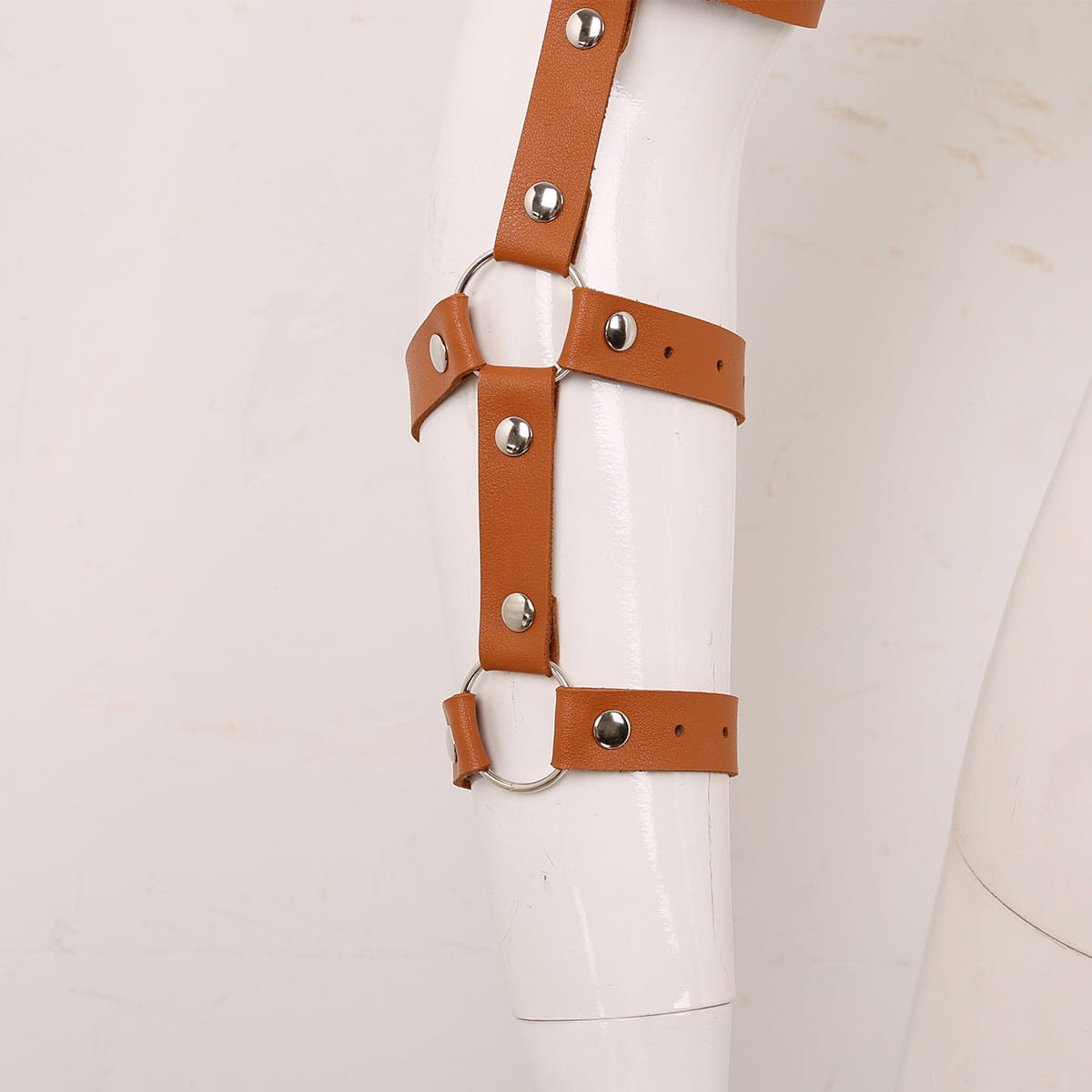 Men’s leather chest harness in tan leather with adjustable straps and silver-toned metal hardware shown from the back side.