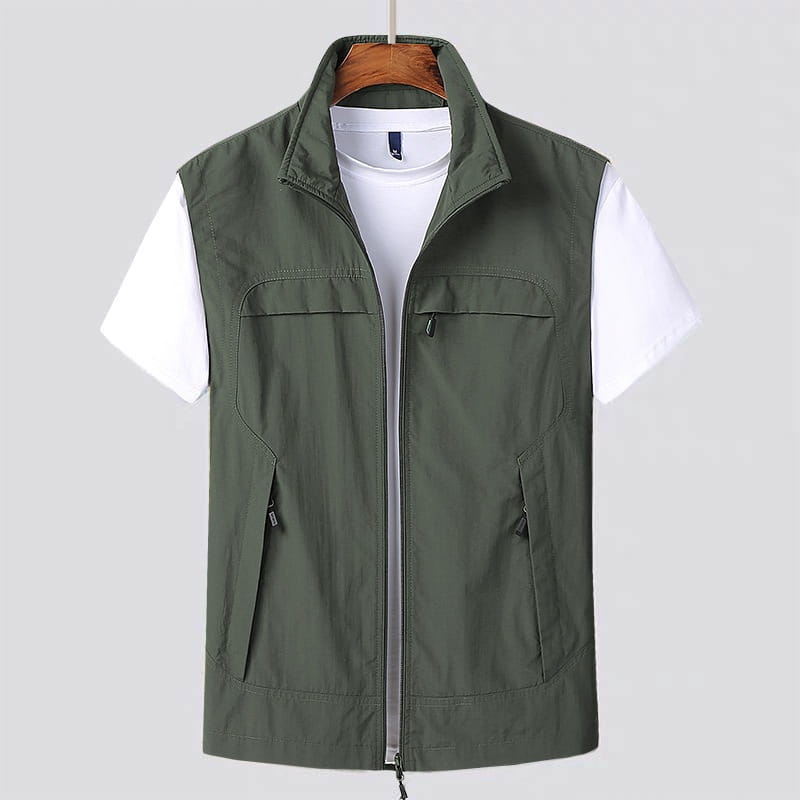 Chaleco utilitario impermeable de color verde oliva con cuello alto, cierre frontal con cremallera y múltiples bolsillos con cremallera, diseñado para un uso práctico.