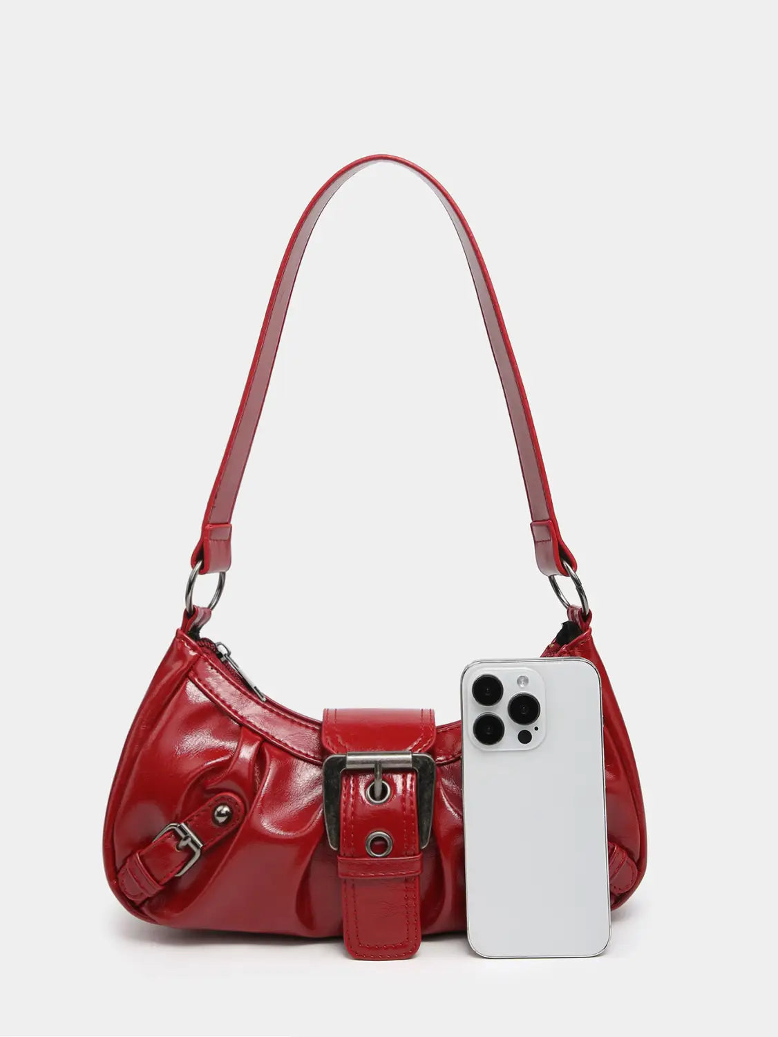 Vintage leather shoulder bag in red patent leather featuring a prominent black buckle and silver-toned hardware accents.