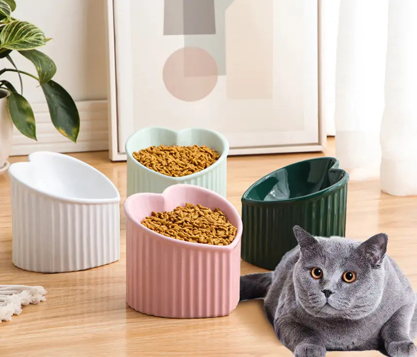 Pink heart-shaped ceramic pet food bowl with vertical ridges and a glossy finish from the Tilted Ceramic Cat Bowl Set 4 Pack.