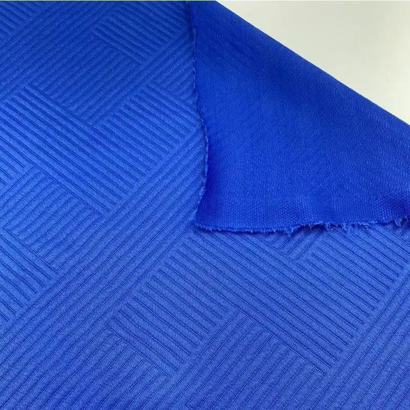 Men’s textured sporty zip hoodie in vibrant royal blue fabric with a woven geometric pattern and orange accents.