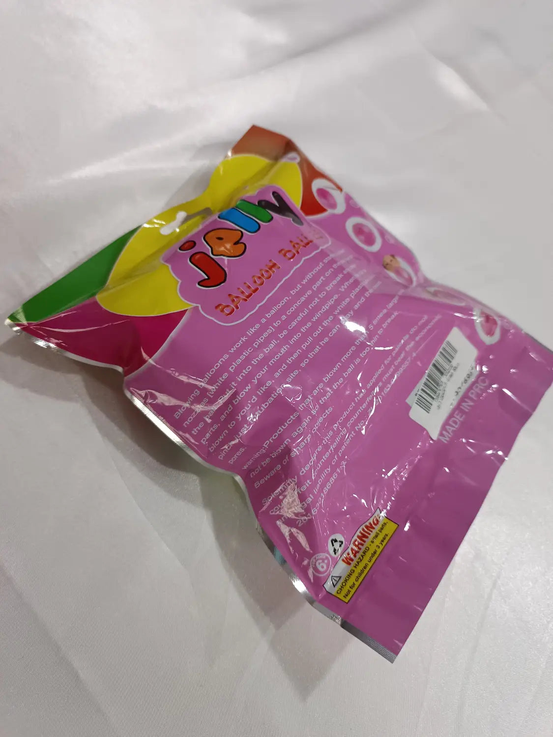Bolsa de plástico rosa que contiene bolas hinchables gigantes de burbuja de TPR, coloridas, tipo globos de agua elásticos.