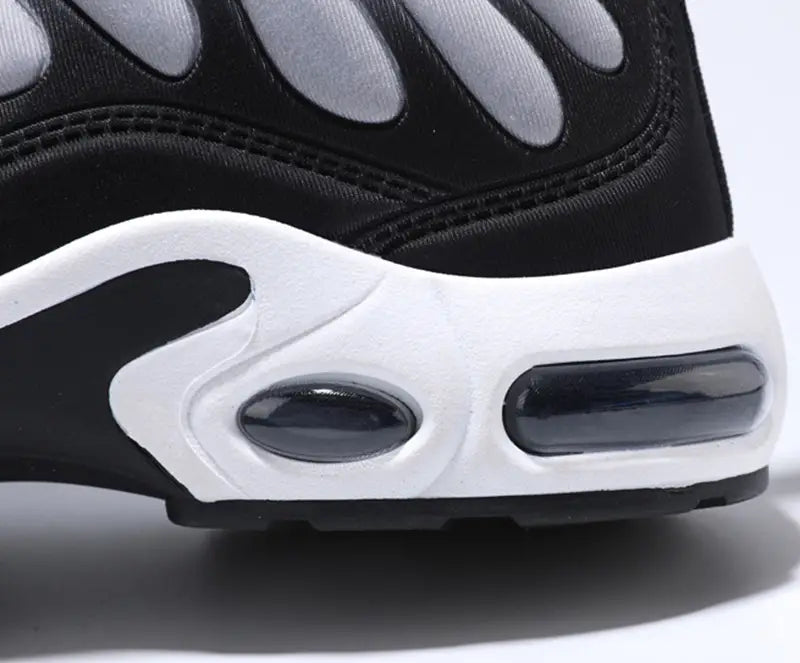 Black and white Nike Air Max 90 sneaker with visible air cushioning unit in the sole designed as air cushion running shoes with flame pattern fashion sneakers.