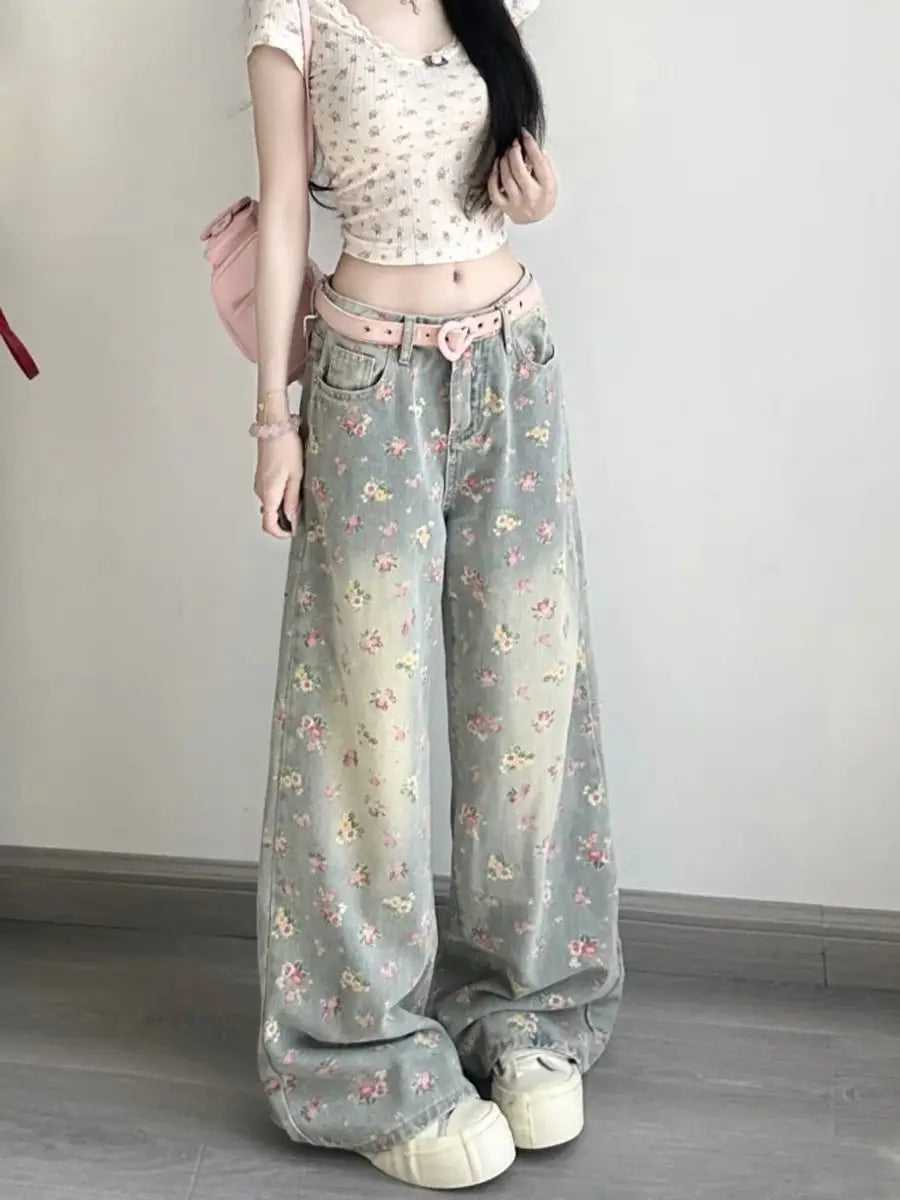 Floral high waist wide leg denim jeans in faded mint green with pink and yellow blossoms paired with a matching heart-shaped belt.