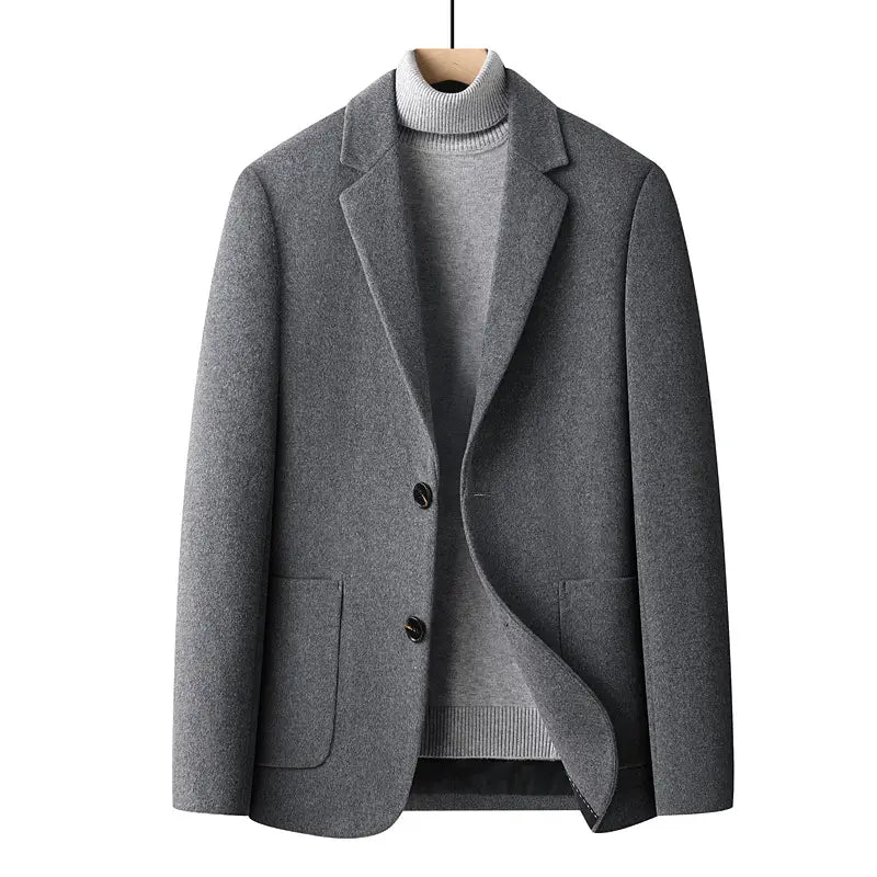 Men’s wool suit blazer slim fit winter jacket in gray with a subtle textured weave and two front flap pockets worn over a matching gray wool turtleneck sweater.