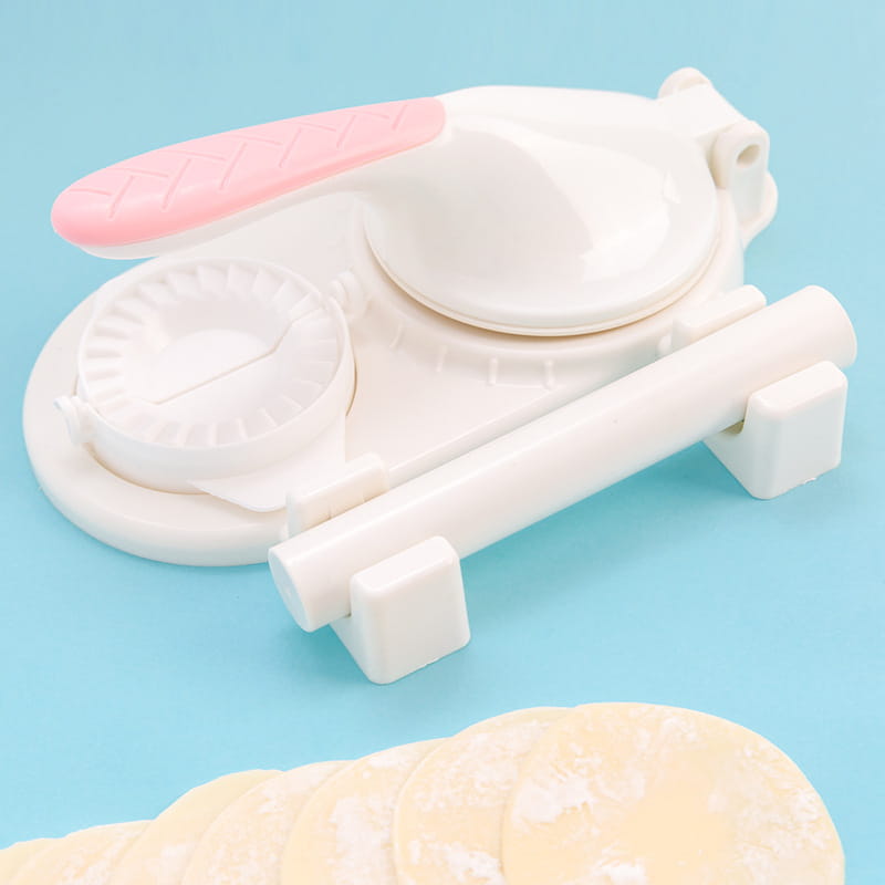 White plastic dumpling maker 3 in 1 manual dough pressing tool with pink textured handle and heart-shaped mold.