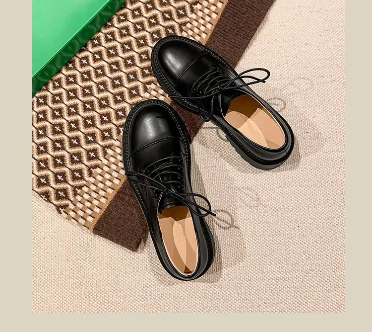 Schwarze Leder-Plateau-Oxfordschuhe im britischen Stil mit glänzender Oberfläche und abgerundetem Vorderkappenbereich, gefertigt aus Rinderleder.