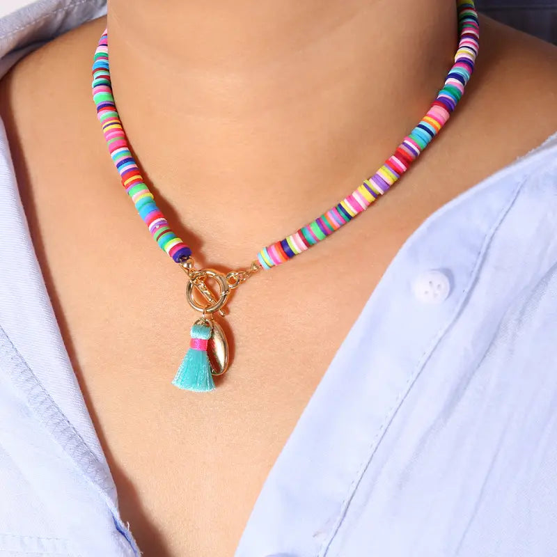 Bohemian rainbow beaded choker necklace featuring colorful beads, a gold-tone toggle clasp, and a turquoise tassel pendant.