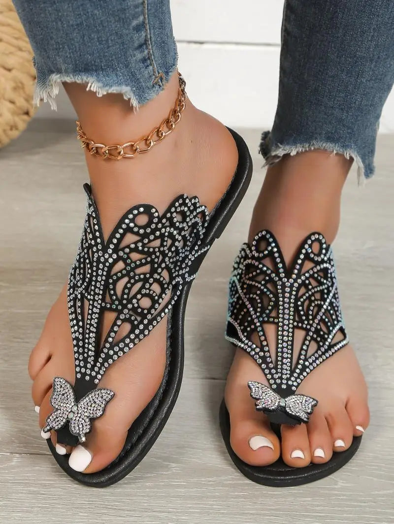 Women’s gold rhinestone hollow flat slip on sandals featuring butterfly embellishments and intricate cutout patterns.
