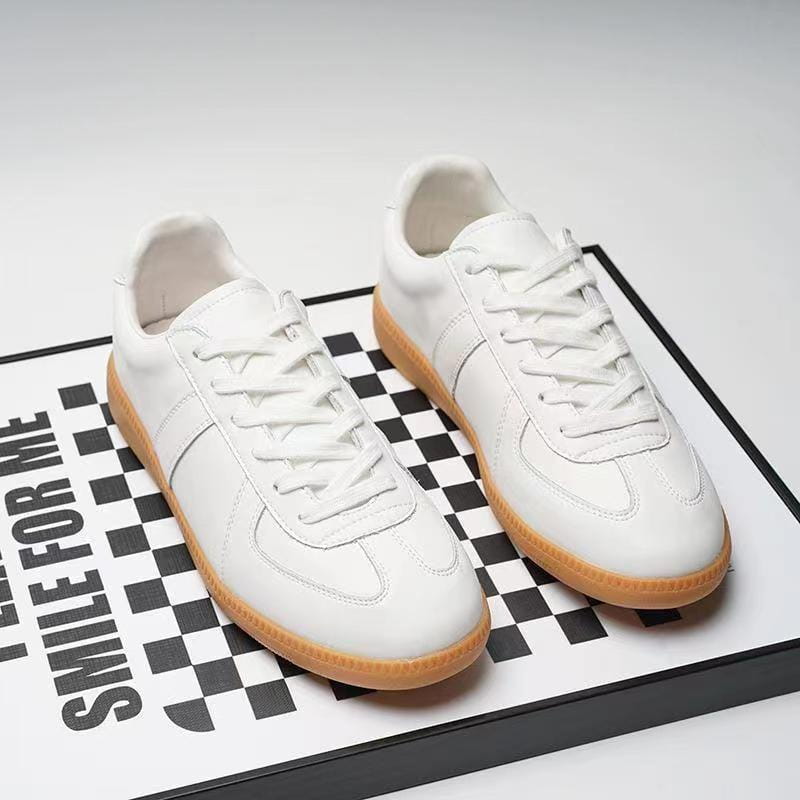 Weiße Ledersneaker mit einer braunen Gummisohle und klassischem Schnürdesign für vielseitige Freizeitschuhe im Low-Top-Design.