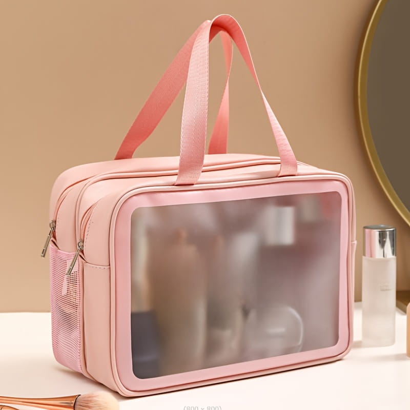 Eine rosafarbene transparente Reisekosmetiktasche mit seitlicher Mesh-Tasche und weichen Stoffgriffen, ausgelegt für Trennung von trocken und nass und zur Organisation der Wäsche.