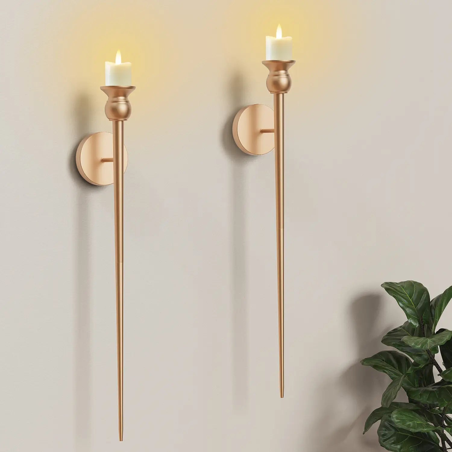 Two elegant gold wall sconces each with a slender stem and an illuminated white battery operated candle measuring 33 inches.
