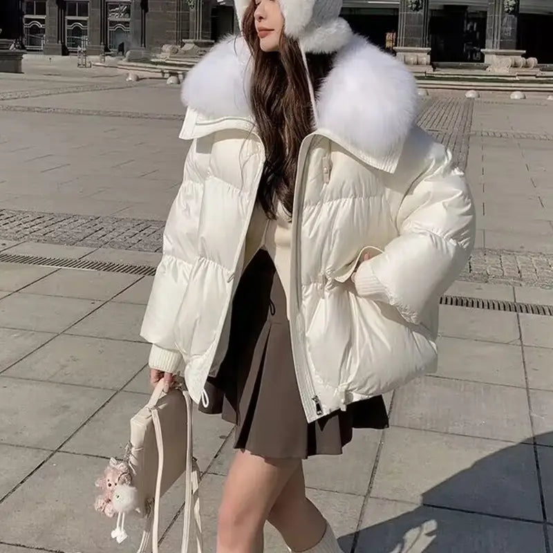 Cream-colored women short down puffer jacket with plush white fur-lined hood designed for warmth and style.