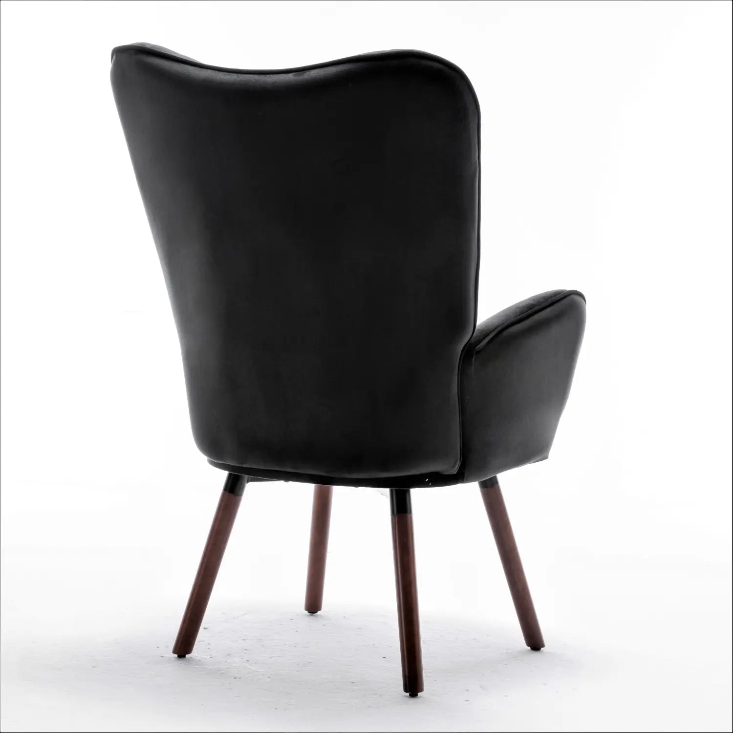 Silla de acento tipo wingback con terciopelo negro acolchado y con botones, con tapizado de cuero negro, respaldo curvo y estilizado, y patas de madera oscura.