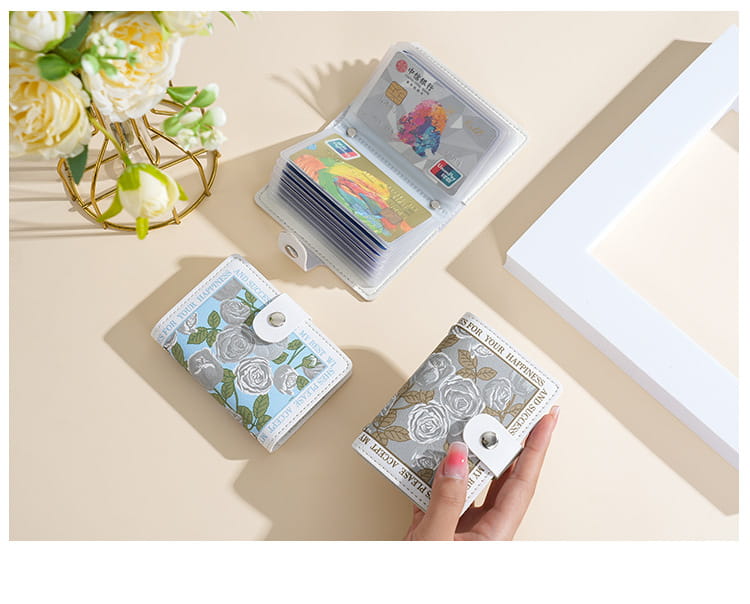 A vintage floral pu leather multi slot card holder wallet in light blue and silver tones with a delicate floral pattern and a white leather-like flap featuring a metallic snap closure.