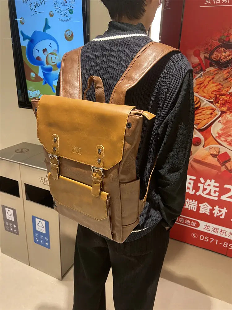 Vintage leather college backpack in tan with brown straps and front flap secured by metal buckles designed for large capacity travel use.
