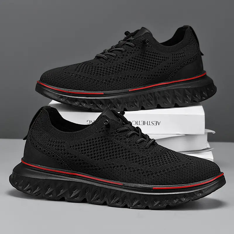 Men’s mesh knit casual lightweight sneakers in black with red accent stitching along the sole edge and a textured rubber outsole.