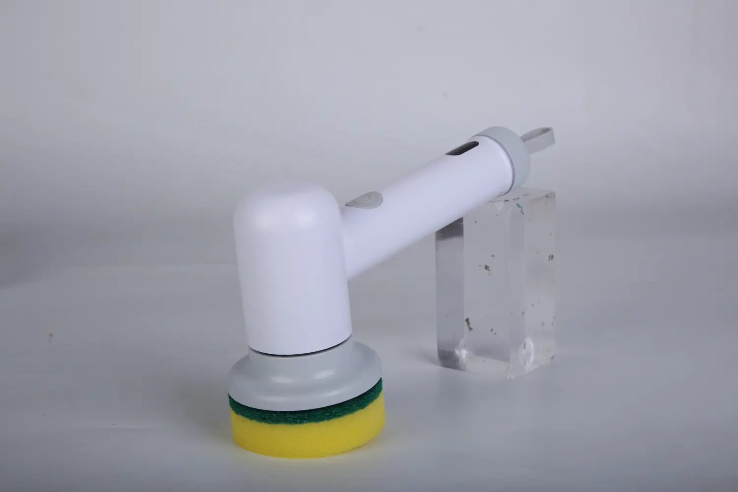 white electric cordless spin scrubber with a yellow and green scrubbing head for efficient cleaning and 4 interchangeable heads