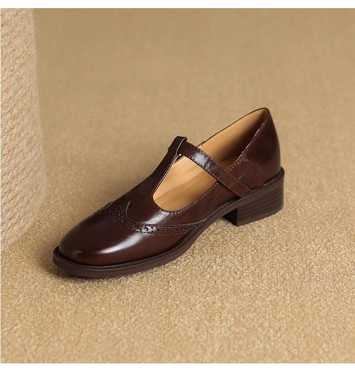 Braune Leder-Brogue-Mary-Jane-Pumps mit klobigem Absatz mit T-Riemen und dekorativer Brogue-Verzierung.