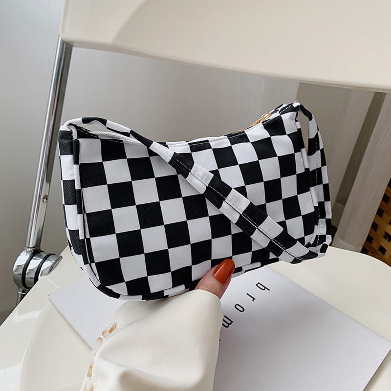Animal print underarm shoulder bag for women featuring a black and white checkered pattern with a gold zipper pull.