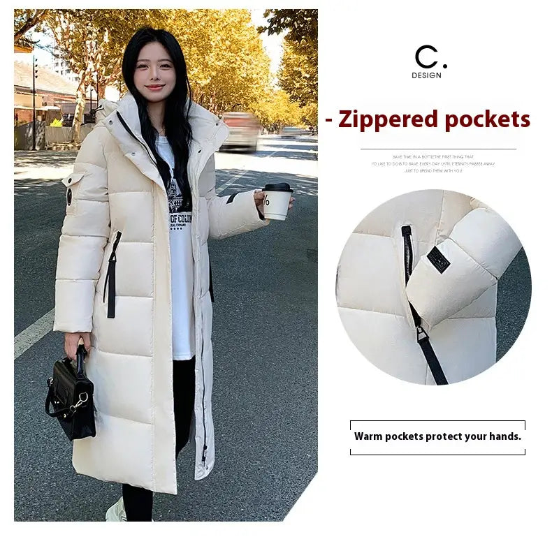Cremefarbener gesteppter Puffer-Mantel mit schwarzen Reißverschluss-Akzenten und Kapuze, ausgelegt als koreanische gesteppte Pufferjacke mit Kapuze.