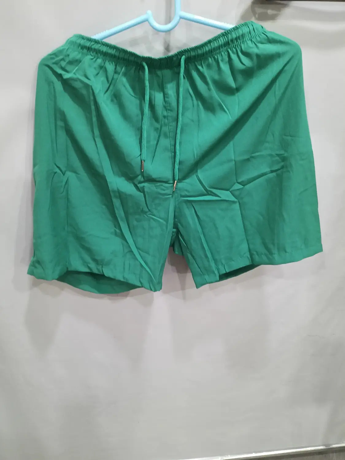 Green printed men beach shorts summer swim trunks featuring an elastic waistband and matching drawstrings designed for athletic use.