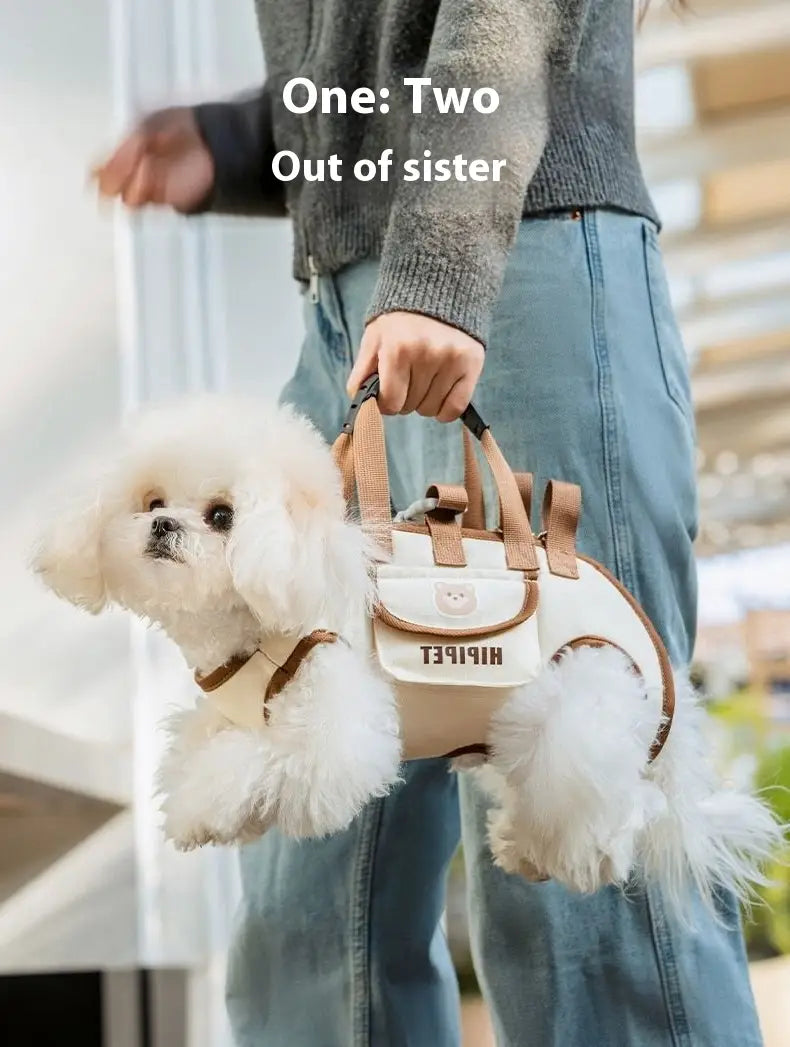 Cream-colored portable pet crossbody handbag mesh dog carrier with tan leather straps and handles featuring a cute face design on the front flap.