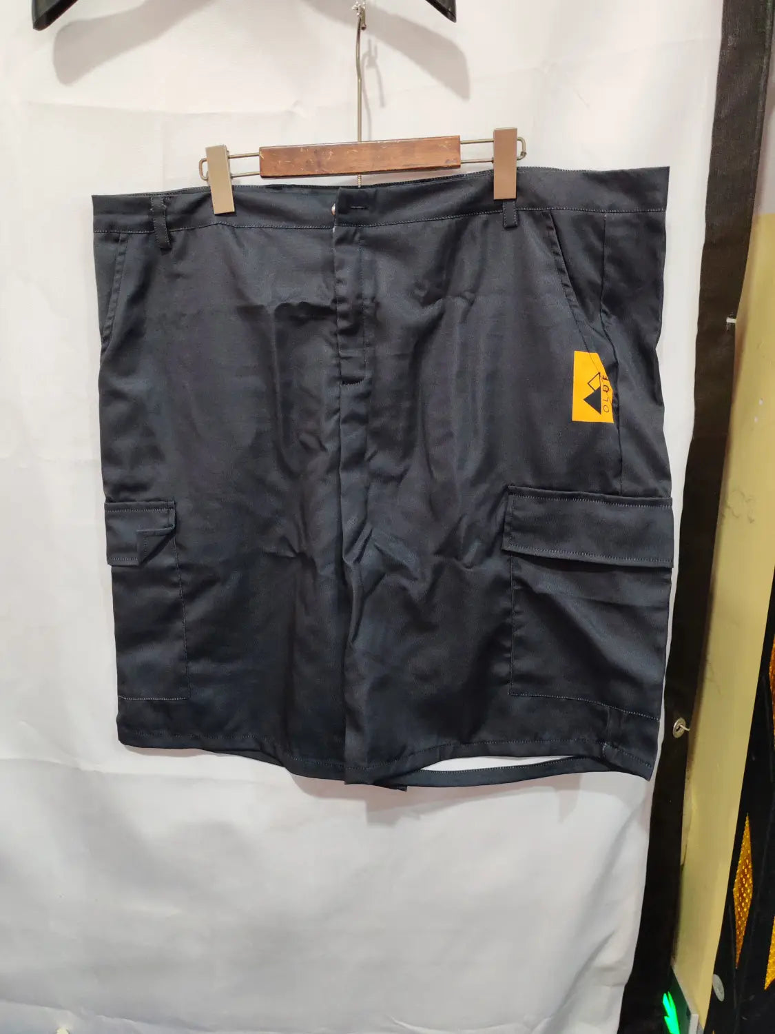 men’s digital print black polyester cargo shorts with multiple pockets and a yellow brand tag on the side