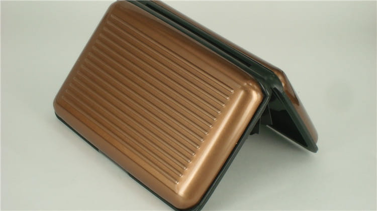 bronze-colored ribbed rfid blocking aluminum alloy card holder case with black interior and hinge open showing inside compartments