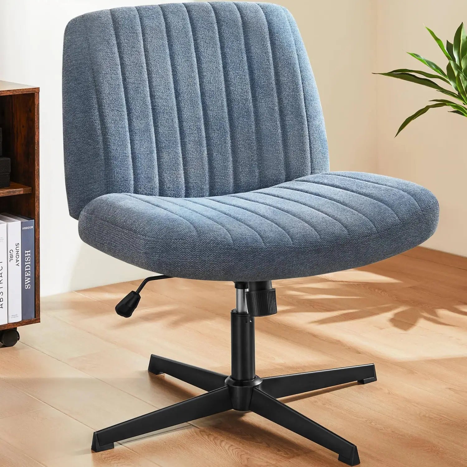 Chaise de bureau en tissu matelassé bleu, à assise croisée, avec base en métal noir et design pivotant large sans accoudoirs pour une utilisation sur bureau.
