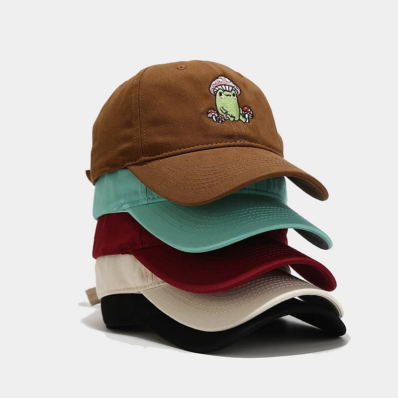 Brown baseball cap featuring an embroidered green frog wearing a pink mushroom hat on the front.