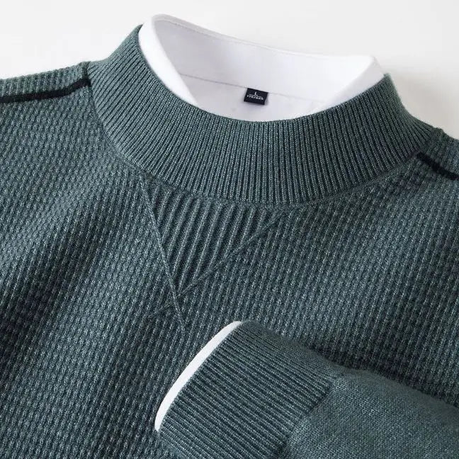 Herren-Pullover aus dunkelgrünem, geripptem Strick mit strukturiertem Stehkragen, mit weißem Innenkragen und Bündchen.