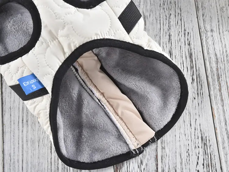 White quilted dog vest with black trim and soft gray fleece lining designed as a windproof warm pet coat.
