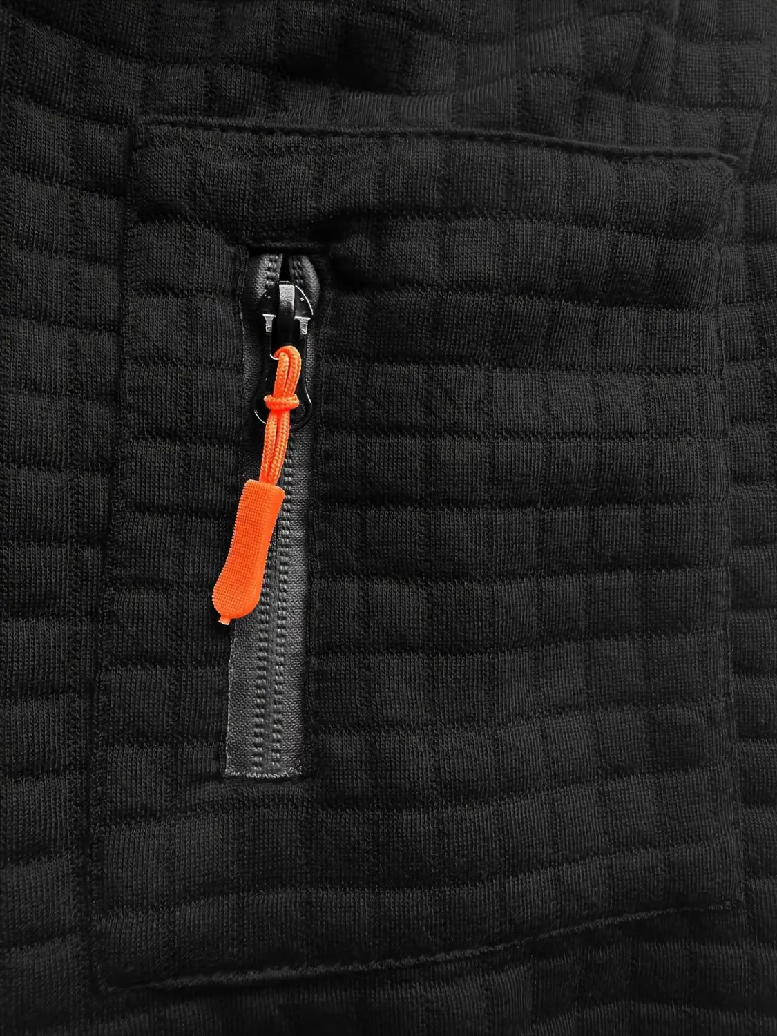 schwarze, wattierte Jacke mit grell orangefarbener Reißverschluss-Zuglasche, kombiniert mit einem karierten Poloshirt für Herren mit langen Ärmeln im strukturierten Sport-/Freizeitstil.